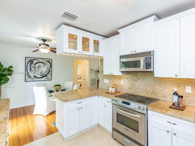 kitchen featuring white cabinetry, light stone counters, stainless steel appliances, and kitchen peninsula