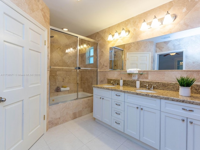 bathroom featuring tile patterned floors, shower / bath combination with glass door, tile walls, and vanity