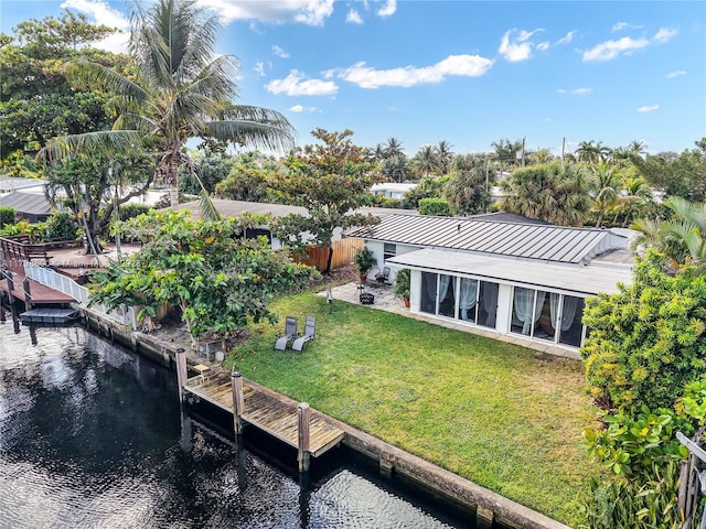 rear view of house featuring a patio, a water view, and a yard