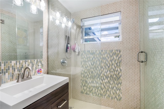 bathroom featuring walk in shower, vanity, tasteful backsplash, and tile walls