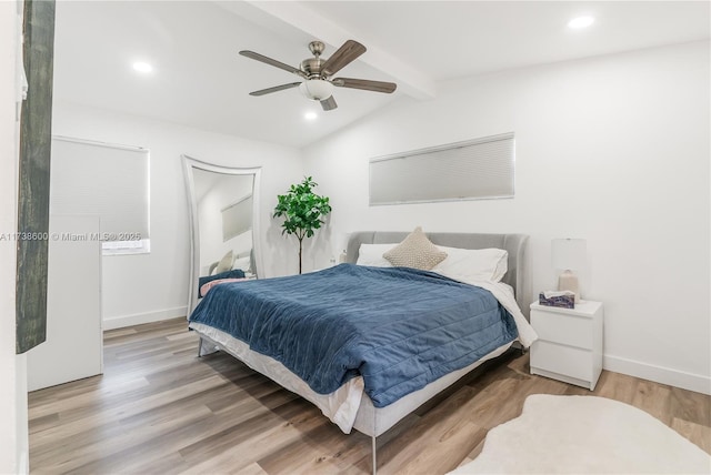 bedroom featuring hardwood / wood-style flooring, ceiling fan, and vaulted ceiling with beams