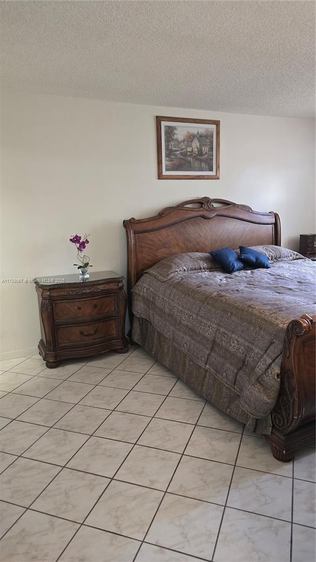 bedroom with light tile patterned floors and a textured ceiling