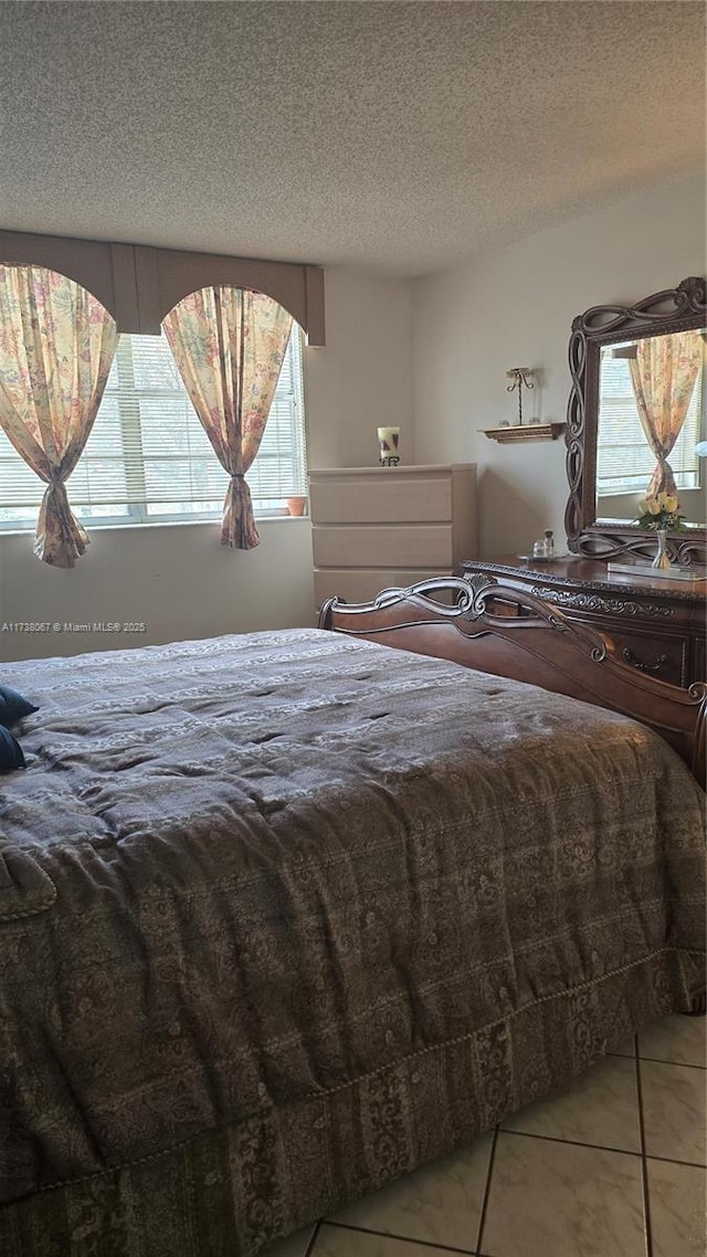 unfurnished bedroom with tile patterned flooring and a textured ceiling