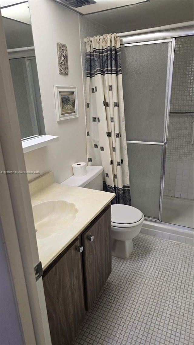 bathroom featuring vanity, curtained shower, tile patterned floors, and toilet