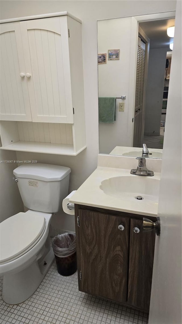 bathroom featuring tile patterned flooring, vanity, and toilet