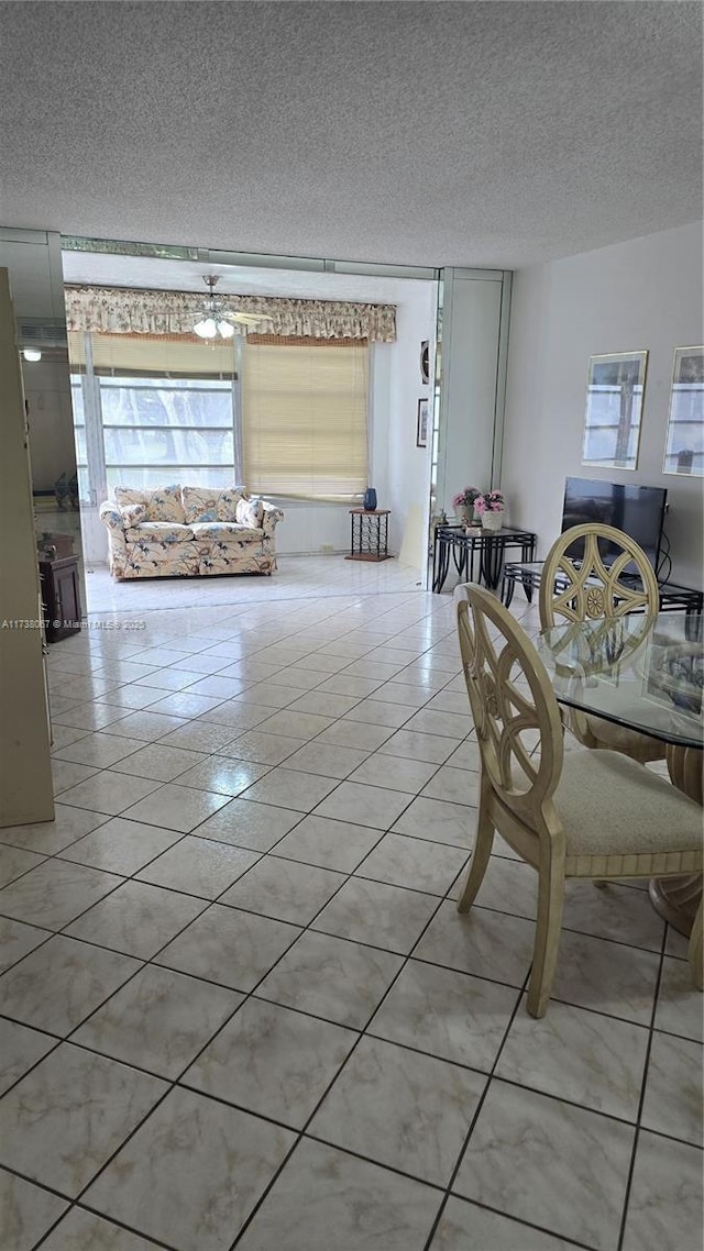 unfurnished dining area featuring light tile patterned floors, plenty of natural light, and a textured ceiling