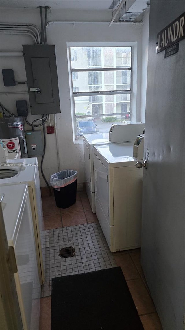 laundry area with light tile patterned floors, electric panel, and washer and clothes dryer