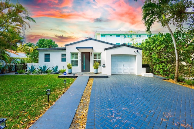 view of front of house with a yard and a garage