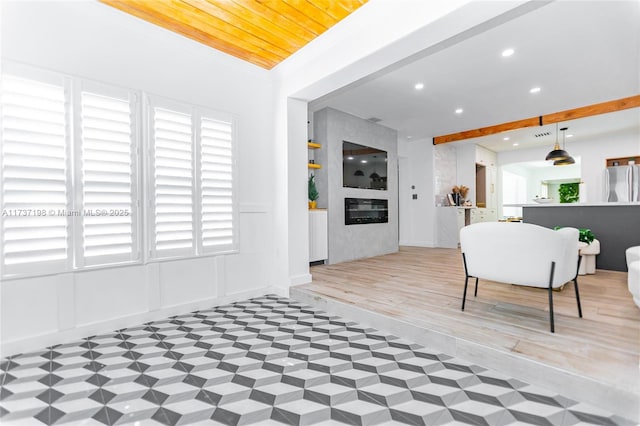 interior space with beamed ceiling, hardwood / wood-style flooring, and a large fireplace