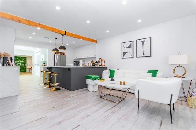 living room featuring beamed ceiling and light wood-type flooring