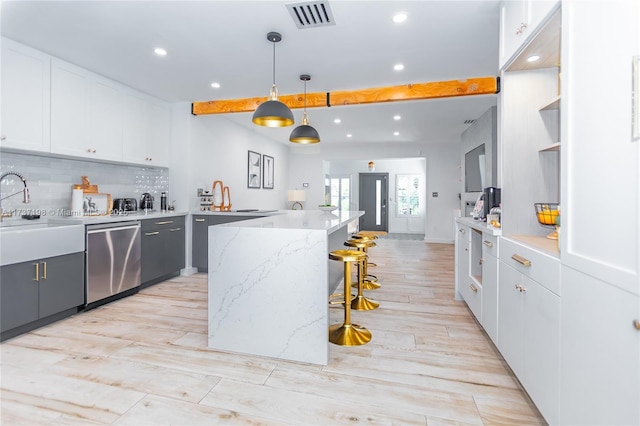 kitchen featuring sink, white cabinetry, hanging light fixtures, decorative backsplash, and stainless steel dishwasher