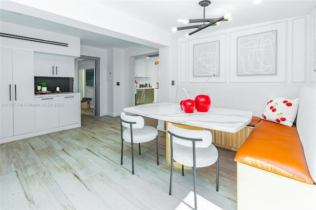 dining space featuring an inviting chandelier, light hardwood / wood-style floors, and breakfast area