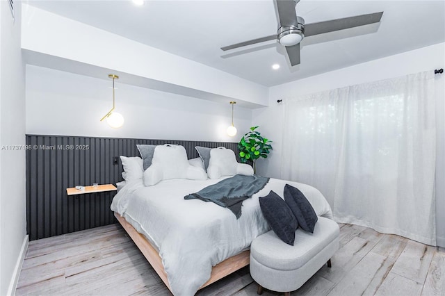 bedroom with ceiling fan and light hardwood / wood-style floors