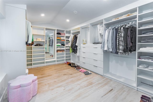 walk in closet featuring hardwood / wood-style flooring and lofted ceiling