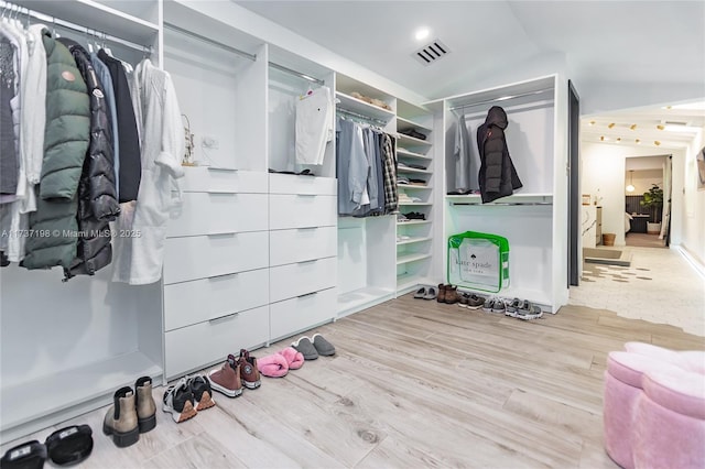 walk in closet featuring lofted ceiling and light hardwood / wood-style floors