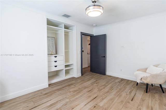 bedroom featuring light hardwood / wood-style flooring, ornamental molding, and a closet