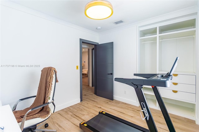 exercise area with hardwood / wood-style floors and ornamental molding