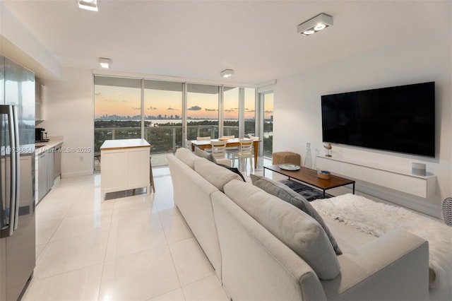 tiled living room featuring floor to ceiling windows