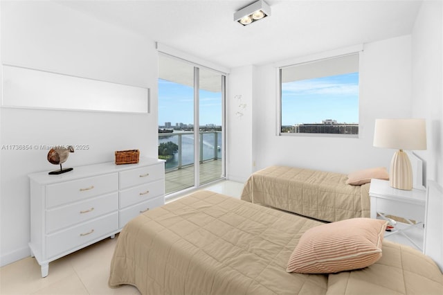 tiled bedroom featuring multiple windows, access to exterior, floor to ceiling windows, and a water view