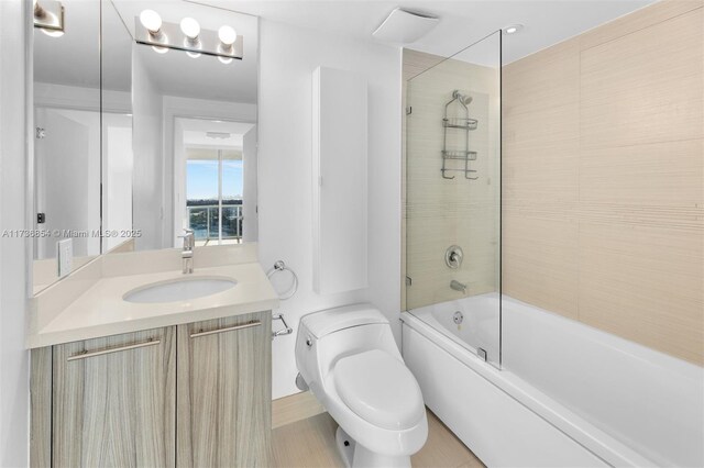 full bathroom with vanity, enclosed tub / shower combo, and toilet