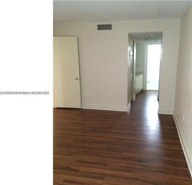 empty room with dark hardwood / wood-style flooring