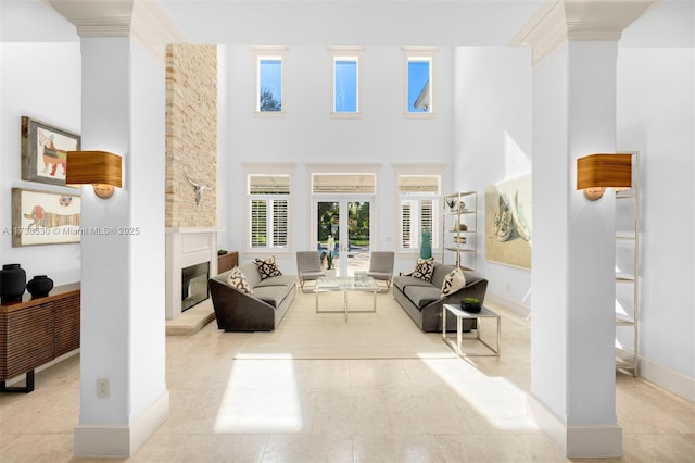 tiled living room with crown molding, a towering ceiling, and french doors