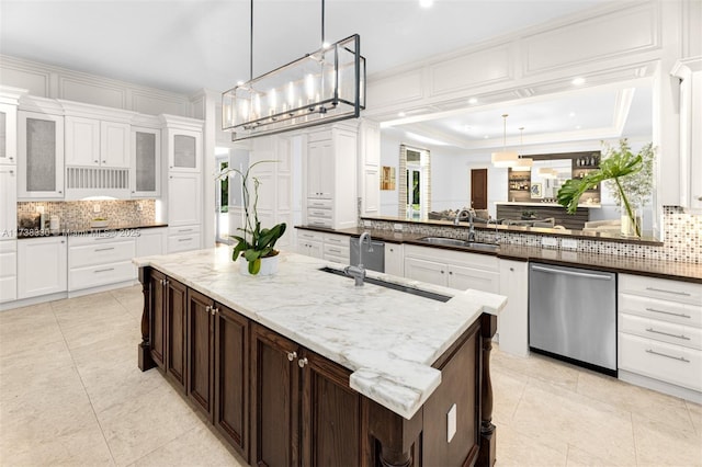 kitchen featuring sink, hanging light fixtures, a center island, stainless steel dishwasher, and dark brown cabinets