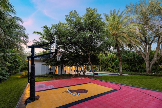 view of sport court with a lawn