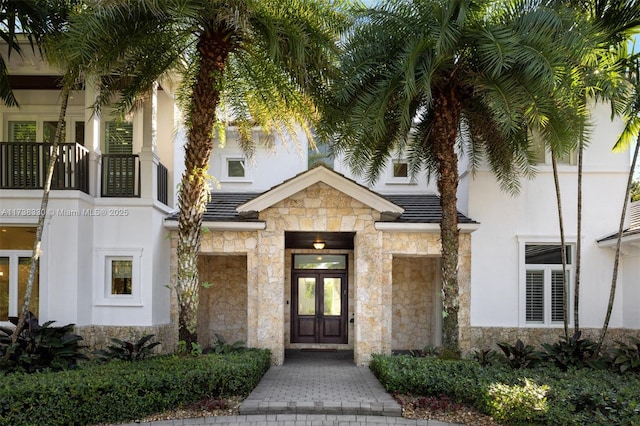 view of exterior entry with a balcony