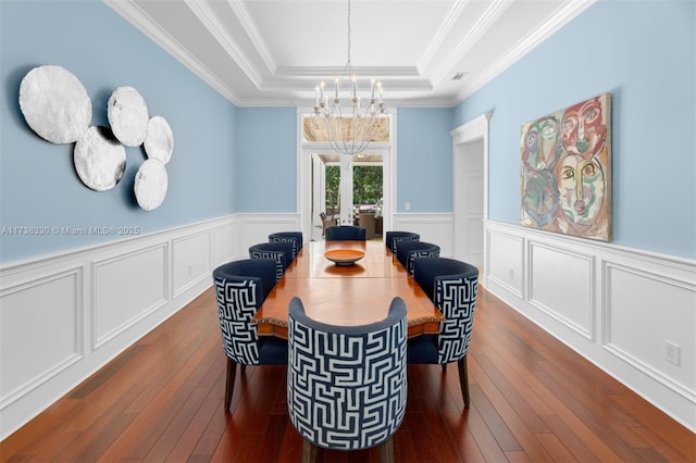 dining space featuring crown molding, an inviting chandelier, dark hardwood / wood-style flooring, and a tray ceiling