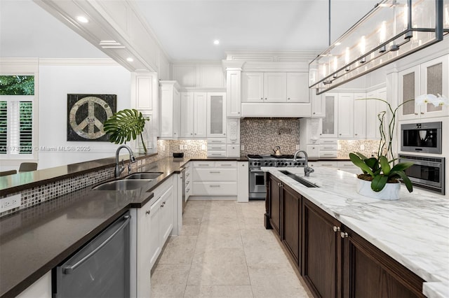 kitchen featuring decorative light fixtures, white cabinetry, sink, backsplash, and stainless steel appliances