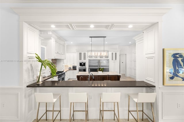 kitchen with white cabinetry, premium appliances, and a breakfast bar