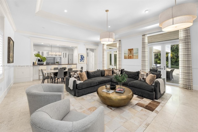 living room featuring a raised ceiling, crown molding, and french doors