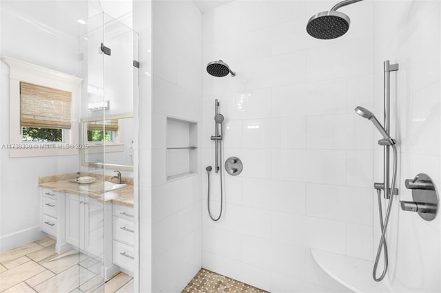 bathroom featuring a tile shower and vanity