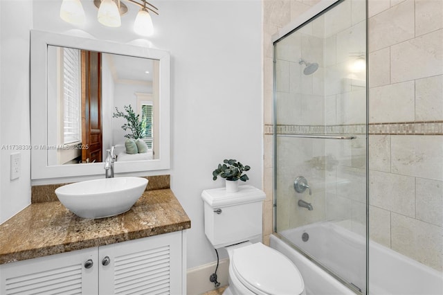 full bathroom with vanity, toilet, and combined bath / shower with glass door