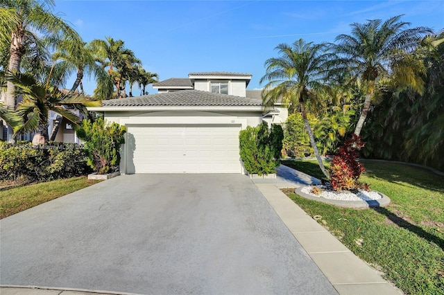 mediterranean / spanish house featuring a garage and a front yard