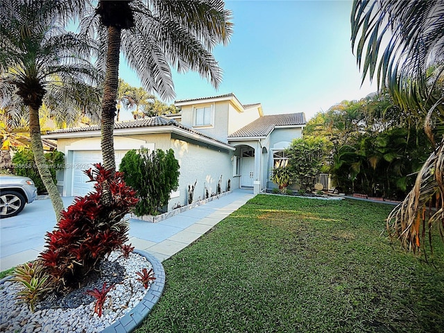 mediterranean / spanish home with a garage and a front lawn