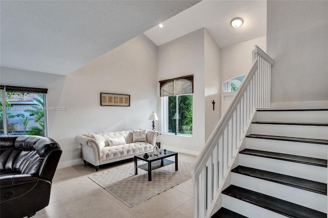 living room with light tile patterned floors, plenty of natural light, and vaulted ceiling