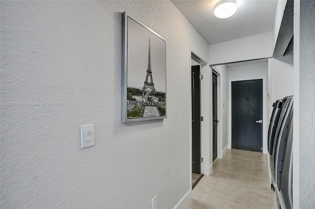 hall with light tile patterned floors and a textured ceiling