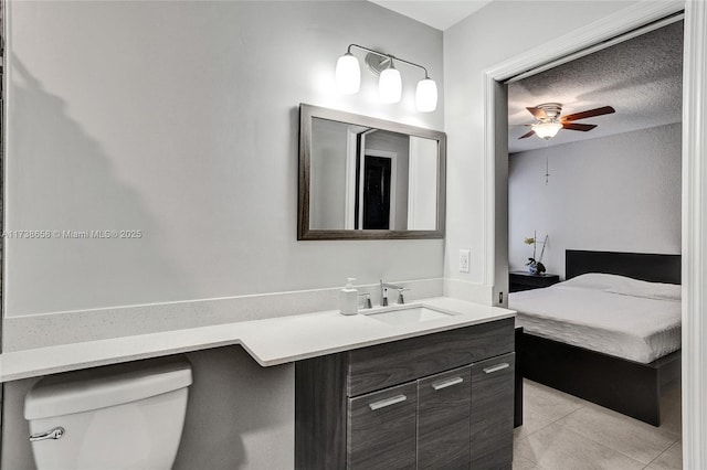 bathroom featuring tile patterned floors, toilet, a textured ceiling, vanity, and ceiling fan