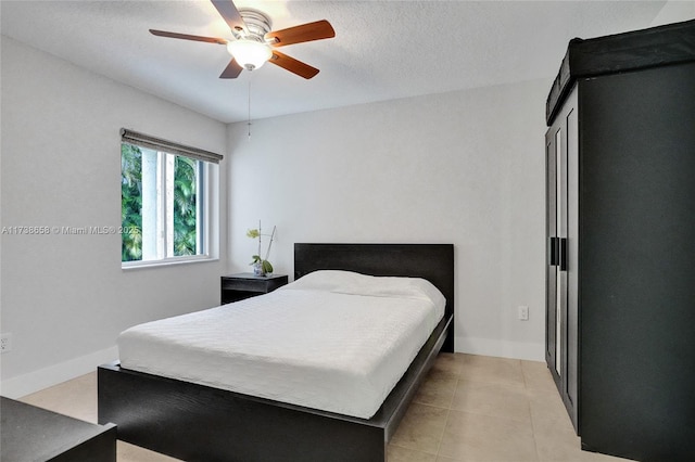 tiled bedroom featuring a textured ceiling and ceiling fan