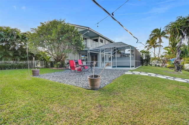 view of yard with a balcony, glass enclosure, and a patio area