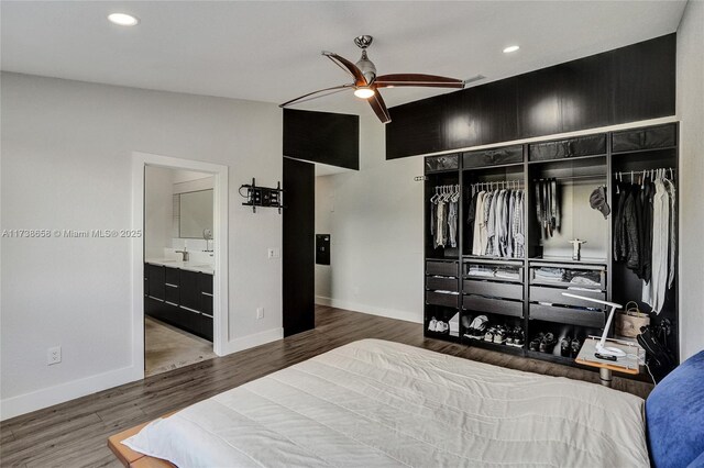 bedroom featuring hardwood / wood-style flooring, ceiling fan, ensuite bathroom, and a closet