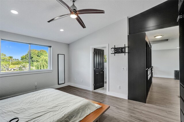 bedroom with hardwood / wood-style flooring, vaulted ceiling, and ceiling fan