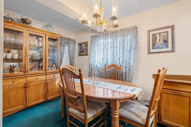 carpeted dining room featuring a textured ceiling and a chandelier