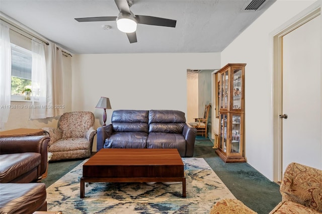 living room featuring dark carpet and ceiling fan