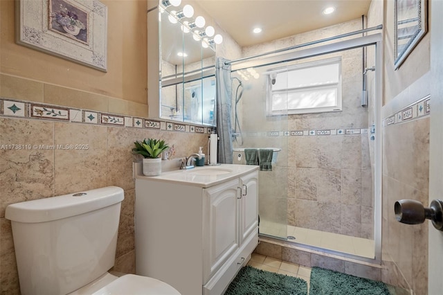 bathroom with tile patterned flooring, tile walls, vanity, toilet, and walk in shower