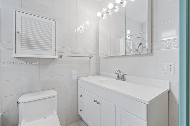 bathroom featuring vanity, tile walls, and toilet