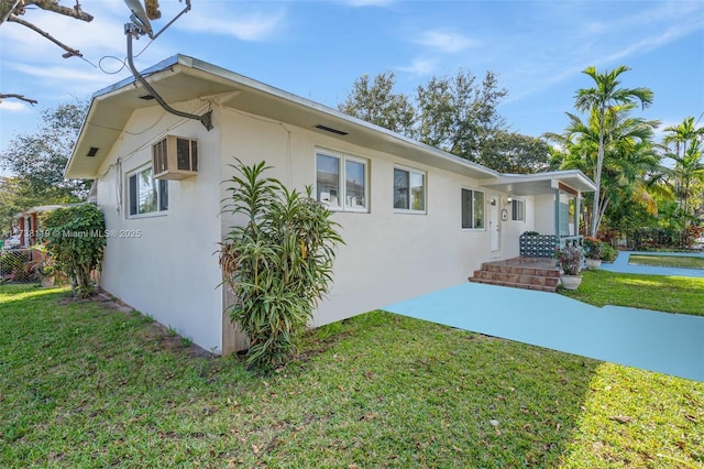 exterior space with a wall mounted AC and a front yard