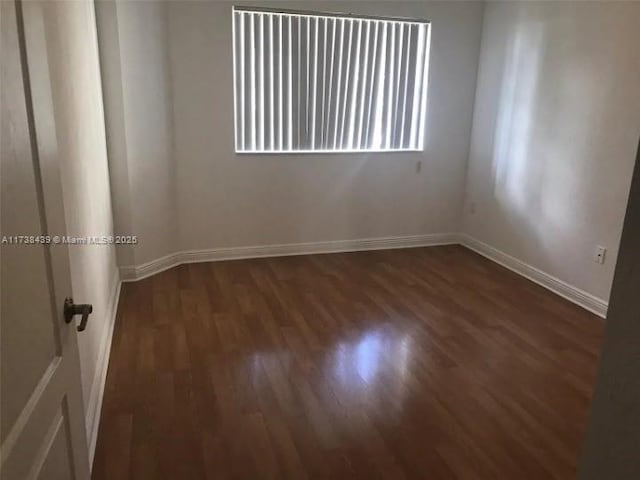 unfurnished room featuring dark wood-type flooring